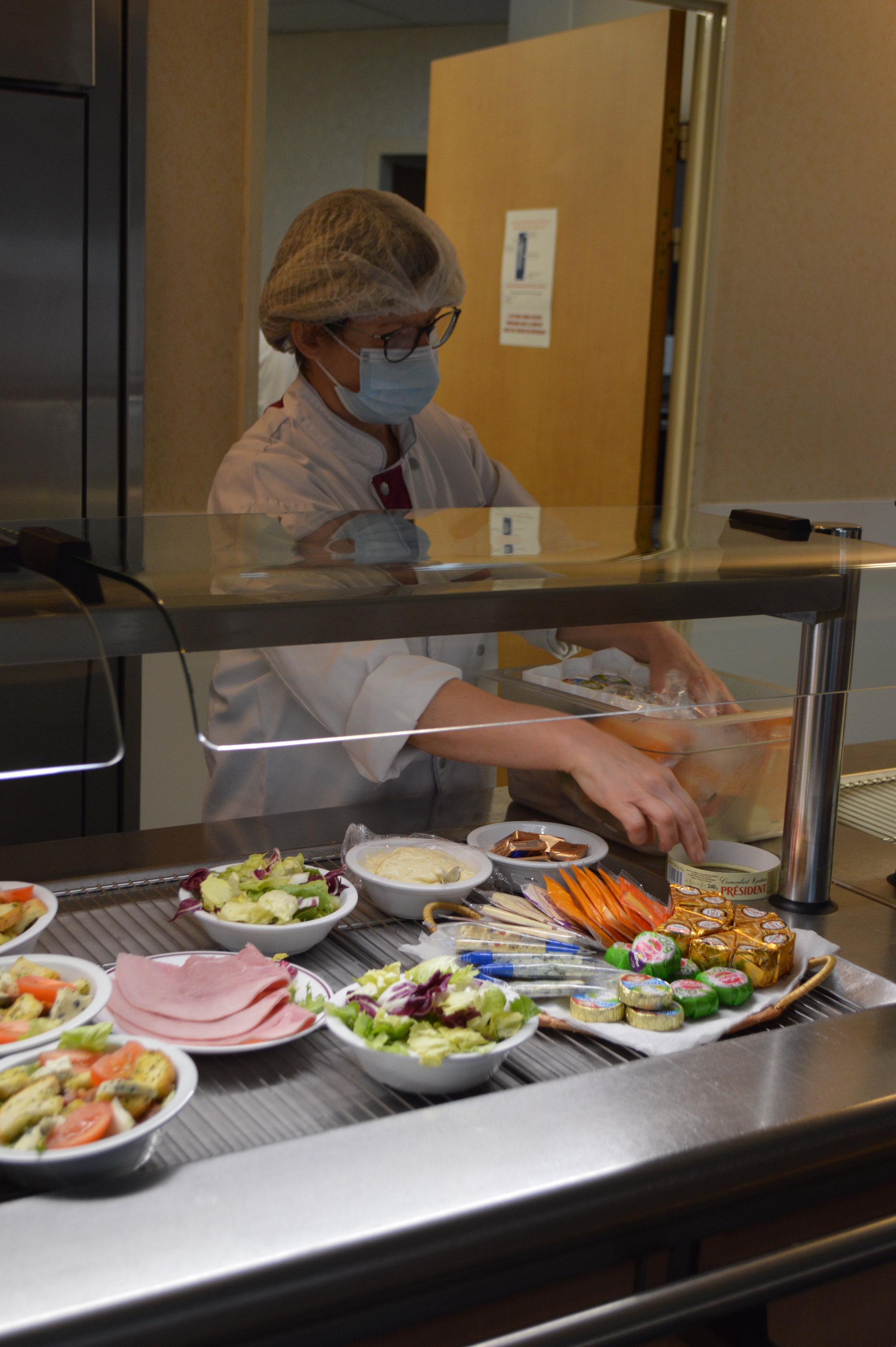 Chaque midi, les agents de la cafétéria du personnel installent les différents produits sur la ligne de service. ©AP Chaque midi, les agents de la cafétéria du personnel installent les différents produits sur la ligne de service. ©AP